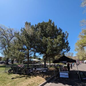 Many bikes corralled in metal gates next to a tent with bike valet staff.